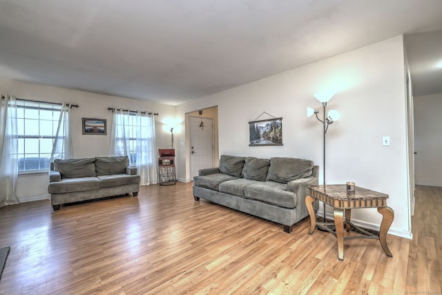 living area featuring baseboards and light wood-type flooring