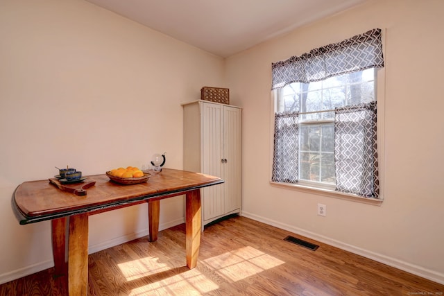 unfurnished dining area featuring wood finished floors, a healthy amount of sunlight, and visible vents
