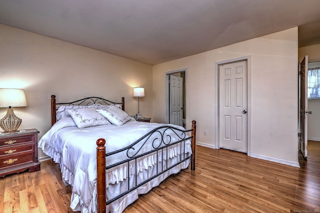 bedroom featuring baseboards and light wood-type flooring