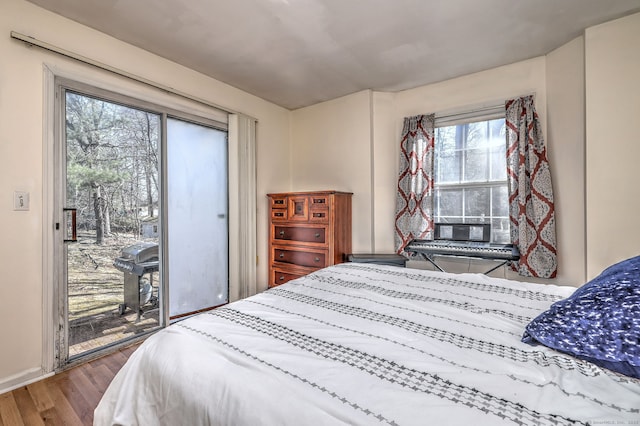 bedroom featuring access to outside and wood finished floors