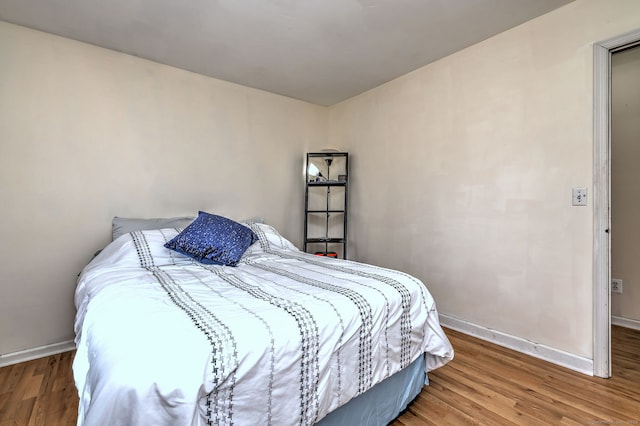 bedroom featuring baseboards and wood finished floors