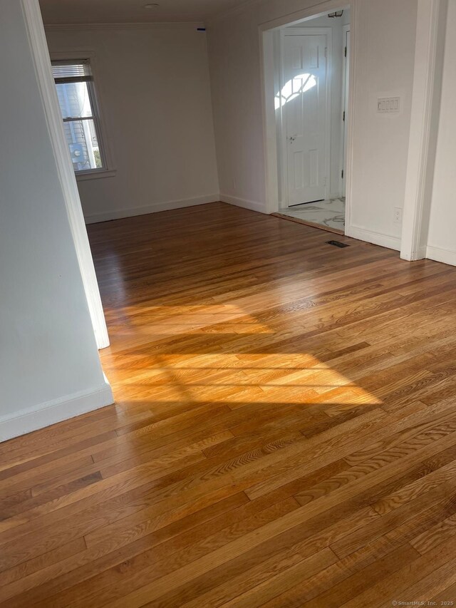 empty room featuring baseboards and light wood finished floors