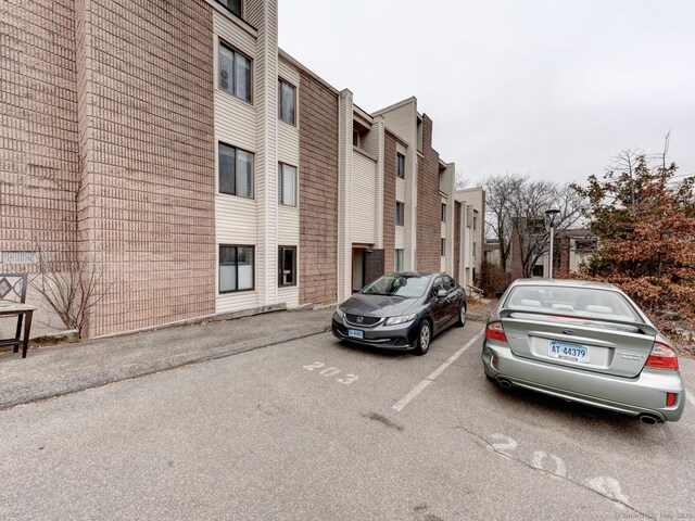 view of building exterior with a residential view and uncovered parking