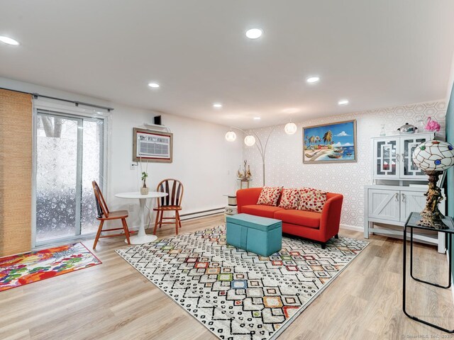 living area featuring recessed lighting, wallpapered walls, a wall unit AC, and wood finished floors