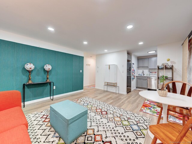 living room with recessed lighting, light wood-type flooring, and baseboards