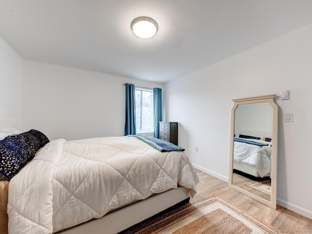 bedroom with baseboards and light wood-style flooring