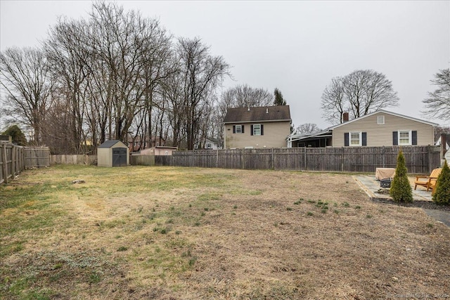 view of yard with an outdoor structure, a fenced backyard, and a shed