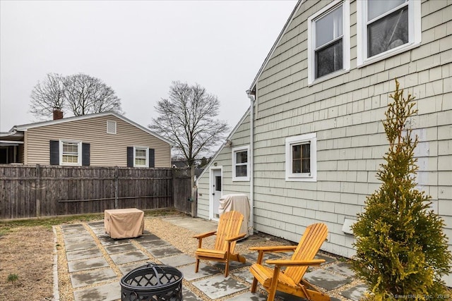 view of patio featuring an outdoor fire pit and fence