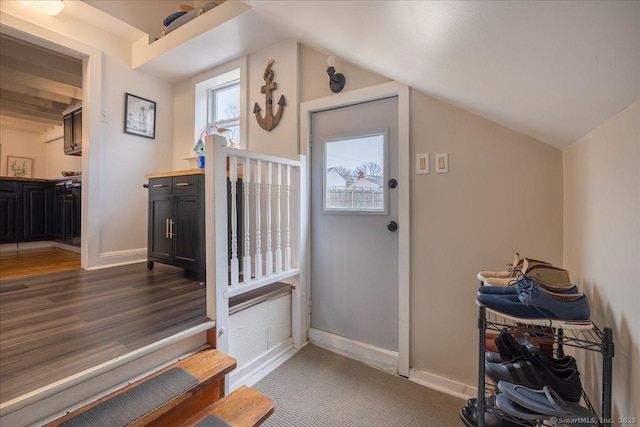 interior space featuring baseboards, lofted ceiling, and dark wood-style flooring