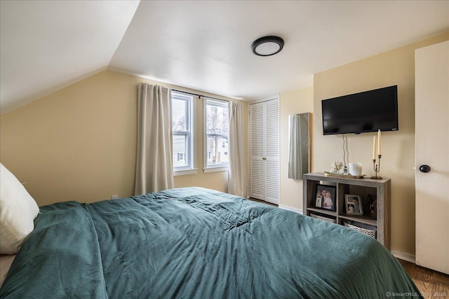 bedroom with a closet, baseboards, and vaulted ceiling