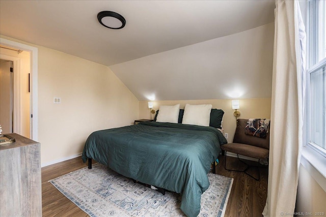 bedroom featuring vaulted ceiling, baseboards, and wood finished floors