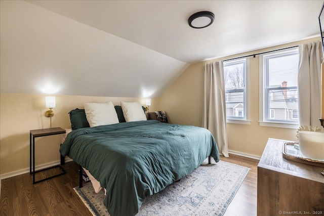 bedroom featuring baseboards, lofted ceiling, and dark wood finished floors