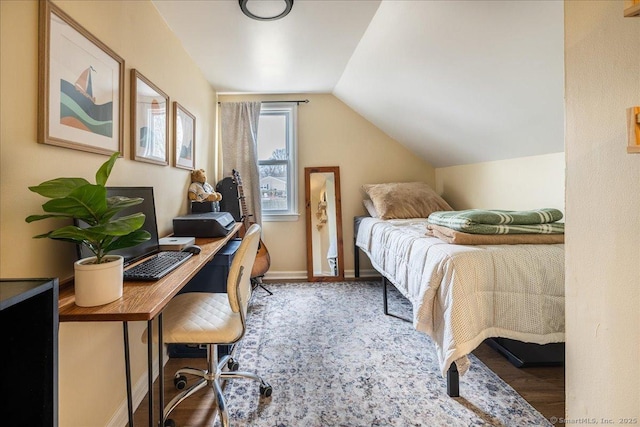 bedroom with baseboards, lofted ceiling, and wood finished floors
