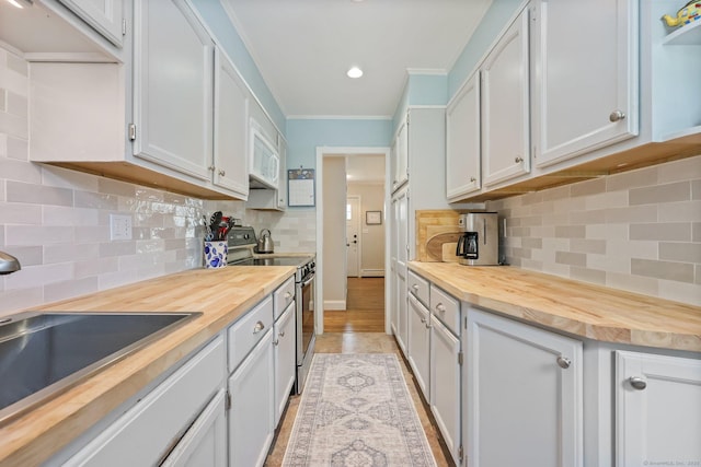 80 Ramapoo Rd, Ridgefield, CT 06877 - kitchen featuring wooden counters, stainless steel range with electric stovetop, white microwave, a sink, and crown molding