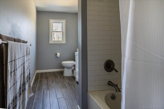 full bathroom featuring shower / bathtub combination with curtain, vanity, toilet, baseboards, and wood finished floors
