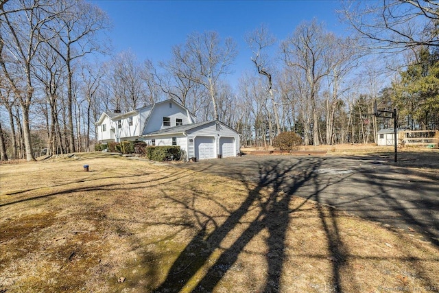 exterior space with a garage and a gambrel roof