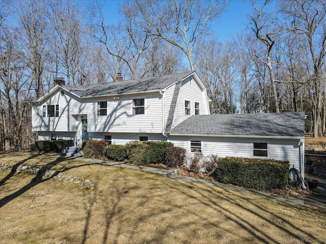 view of side of property with a chimney, entry steps, and a yard