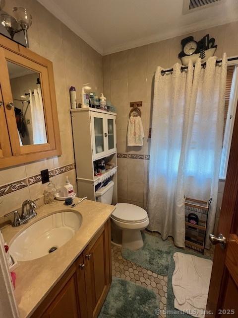 12 Avery St, Stonington, CT 06379 - bathroom featuring tile walls, vanity, toilet, tile patterned floors, and ornamental molding