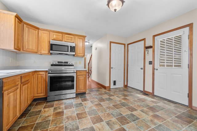 32 Pheasant Hill Dr Unit 32, Enfield, CT 06082 - kitchen featuring appliances with stainless steel finishes, dark stone finish flooring, light countertops, and backsplash