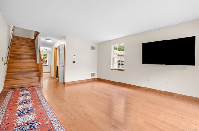32 Pheasant Hill Dr Unit 32, Enfield, CT 06082 - unfurnished living room with light wood-style flooring and stairs