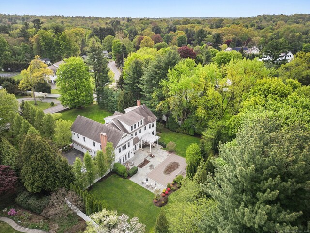 aerial view of property and surrounding area featuring a heavily wooded area