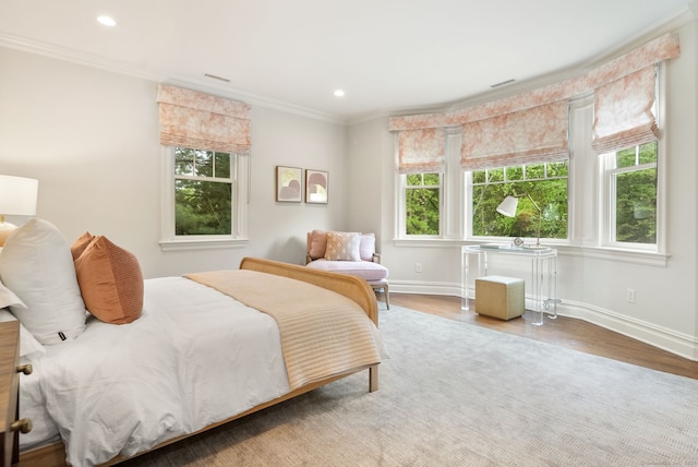 bedroom featuring multiple windows, baseboards, ornamental molding, wood finished floors, and recessed lighting