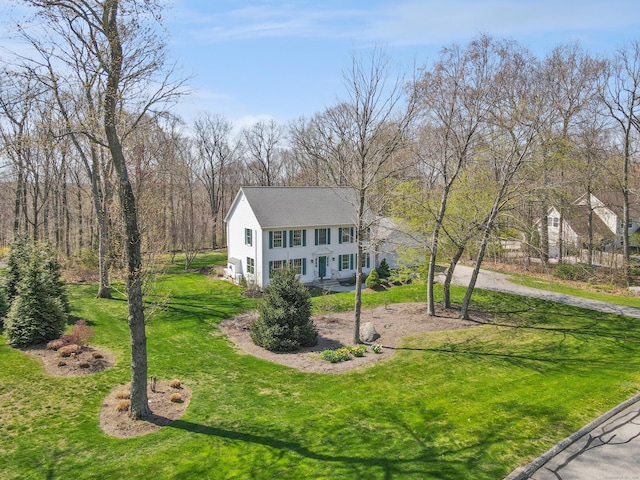 view of front of home featuring a front lawn, roof with shingles, and driveway