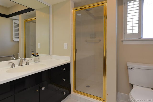 full bathroom with vanity, a shower stall, and toilet