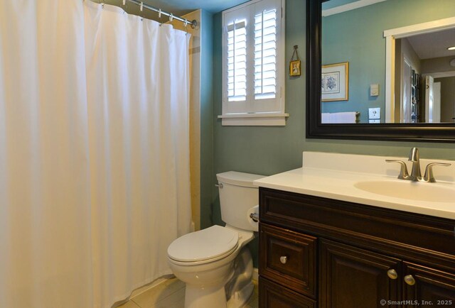 full bath featuring tile patterned flooring, a shower with shower curtain, toilet, and vanity