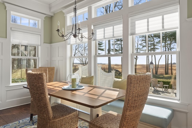 sunroom with plenty of natural light and a notable chandelier