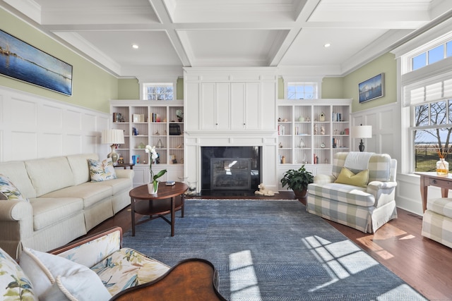 living area featuring a decorative wall, a large fireplace, coffered ceiling, and beamed ceiling