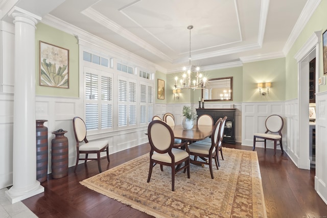 dining area with a tray ceiling, a decorative wall, and decorative columns