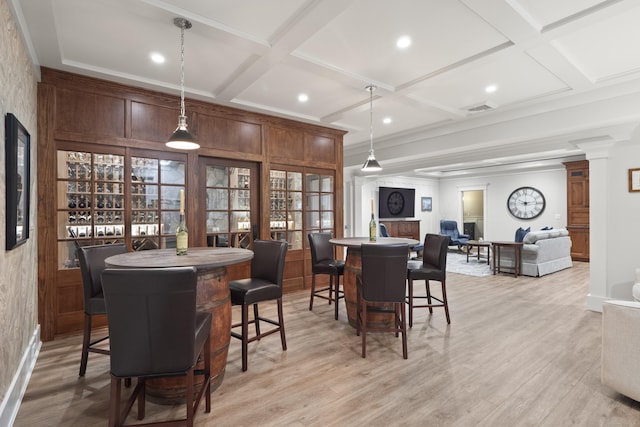 dining area with coffered ceiling, visible vents, a bar, light wood-type flooring, and decorative columns