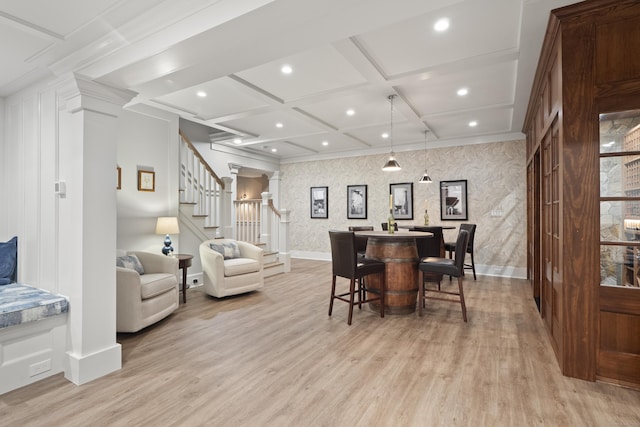 dining space featuring light wood-style flooring, baseboards, and stairway