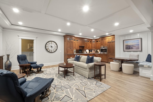 living area featuring recessed lighting, ornamental molding, a decorative wall, baseboards, and light wood-style flooring