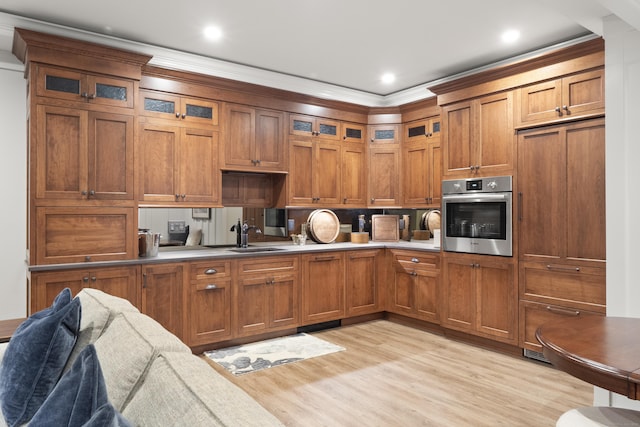 kitchen featuring brown cabinets, stainless steel oven, and a sink