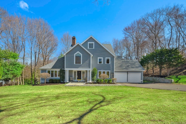 view of front of house with a front yard, driveway, a garage, and a chimney