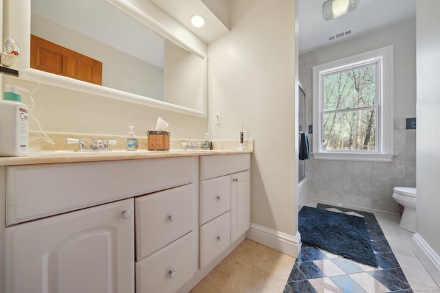 16 Fullmar Ln, Norwalk, CT 06850 - full bathroom featuring double vanity, enclosed tub / shower combo, tile walls, and tile patterned flooring