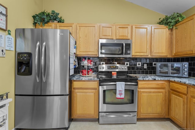 kitchen featuring a toaster, backsplash, stainless steel appliances, and vaulted ceiling