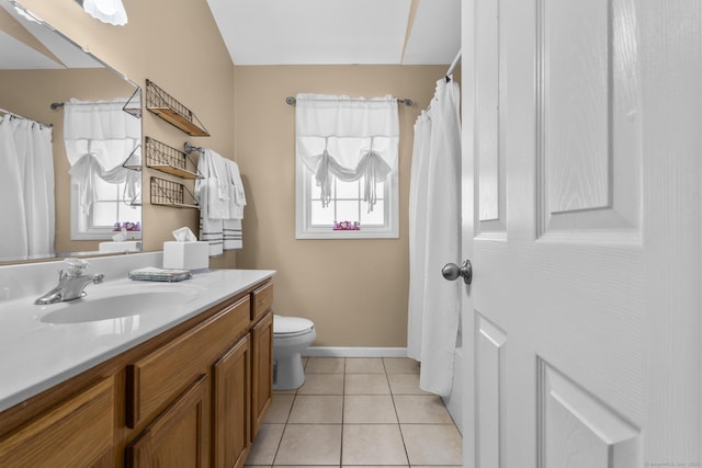 bathroom featuring toilet, tile patterned floors, plenty of natural light, and vanity