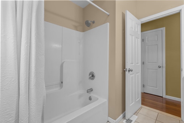 bathroom featuring tile patterned flooring, shower / bath combination with curtain, and baseboards