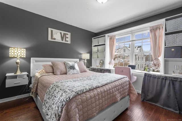 bedroom with dark wood-style floors and baseboards