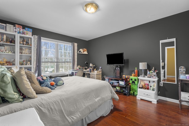 bedroom with wood finished floors and baseboards