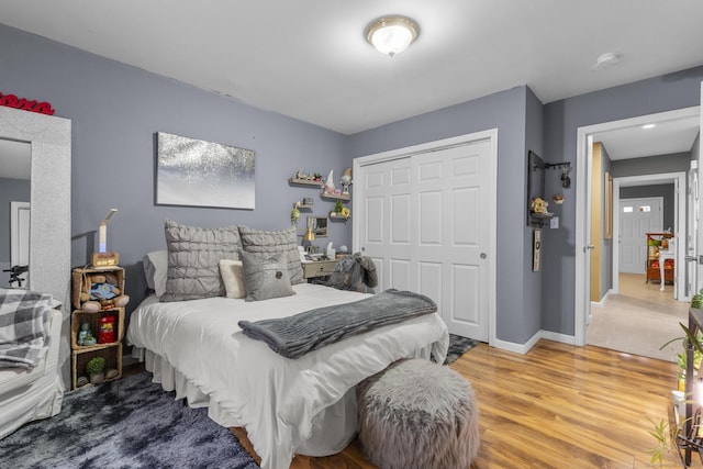 bedroom featuring a closet, baseboards, and wood finished floors