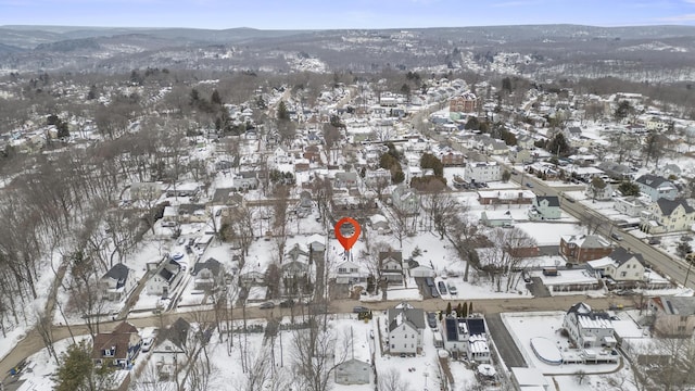 snowy aerial view featuring a mountain view and a residential view