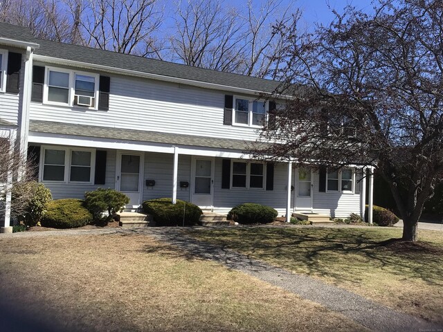 view of front facade featuring roof with shingles and a porch
