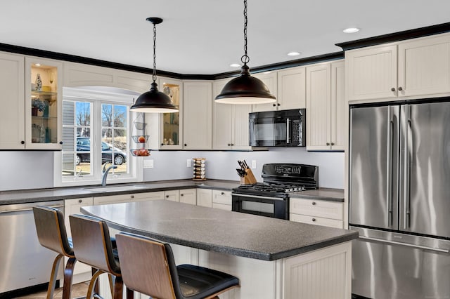106 Chesterfield Rd, East Lyme, CT 06333 - kitchen with black appliances, a sink, dark countertops, a kitchen breakfast bar, and glass insert cabinets