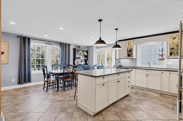 106 Chesterfield Rd, East Lyme, CT 06333 - kitchen featuring dark countertops, recessed lighting, light tile patterned floors, and glass insert cabinets