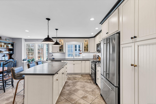 106 Chesterfield Rd, East Lyme, CT 06333 - kitchen with freestanding refrigerator, double oven range, dark countertops, glass insert cabinets, and a center island