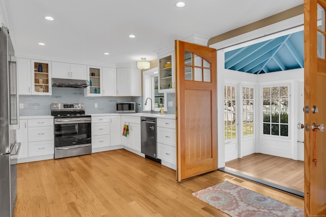 387 N River St, Guilford, CT 06437 - kitchen with stainless steel appliances, under cabinet range hood, light countertops, light wood-type flooring, and decorative backsplash
